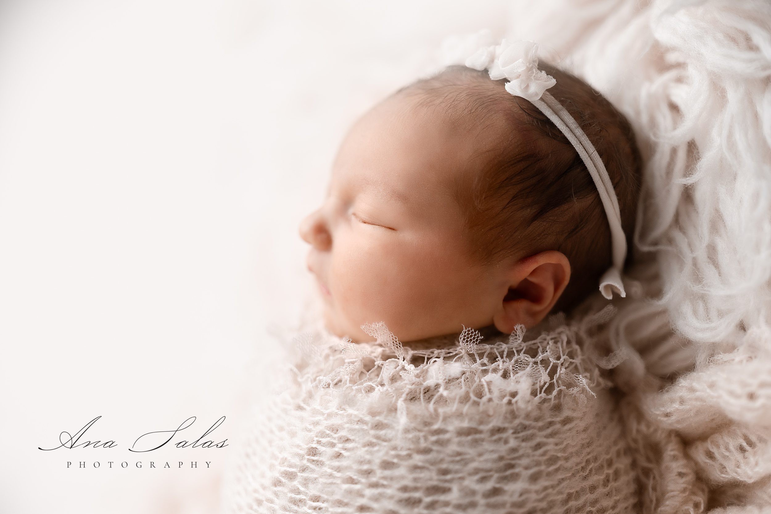 A profile image of a sleeping newborn baby in a white knit swaddle after visiting the fourth edmonton